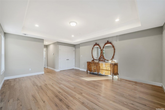 interior space featuring light hardwood / wood-style floors and a raised ceiling