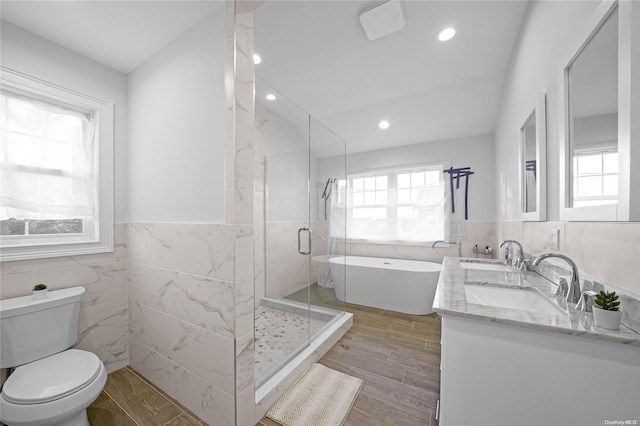 full bathroom with shower with separate bathtub, hardwood / wood-style flooring, plenty of natural light, and tile walls