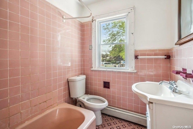 full bathroom with  shower combination, vanity, a baseboard heating unit, tile walls, and toilet