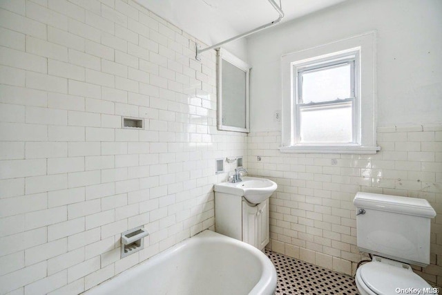 bathroom with vanity, a tub to relax in, toilet, and tile walls