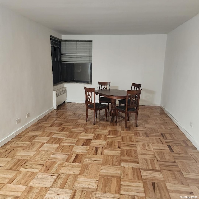 dining area featuring light parquet flooring and radiator