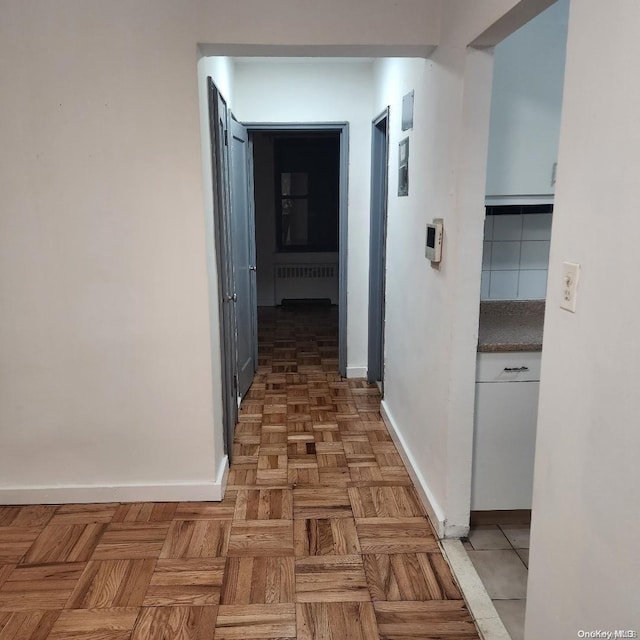 hall featuring parquet flooring and radiator