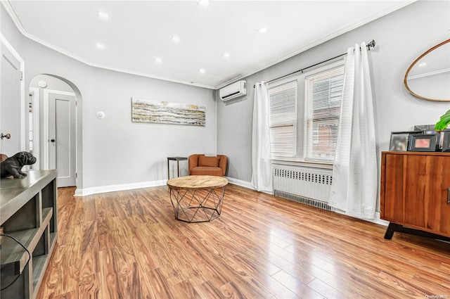 living area with a wall unit AC, radiator, light hardwood / wood-style flooring, and ornamental molding