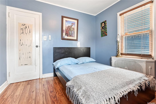 bedroom featuring hardwood / wood-style flooring and ornamental molding