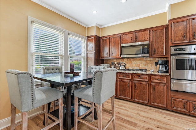 47 Alden Ave, Valley Stream, NY 11580 - kitchen featuring a warming drawer, stainless steel appliances, light wood-style flooring, decorative backsplash, and ornamental molding