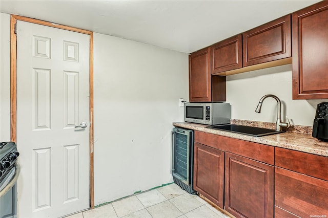 kitchen with wine cooler, sink, light tile patterned floors, and stainless steel appliances