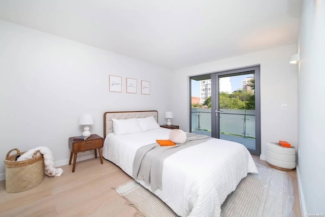 bedroom with light wood-type flooring and access to outside