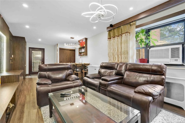 living room with radiator heating unit, light hardwood / wood-style floors, cooling unit, and a notable chandelier