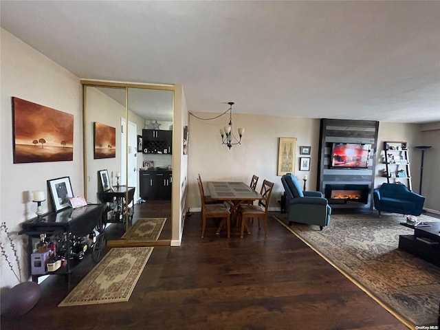 living room featuring dark hardwood / wood-style floors, a fireplace, and an inviting chandelier