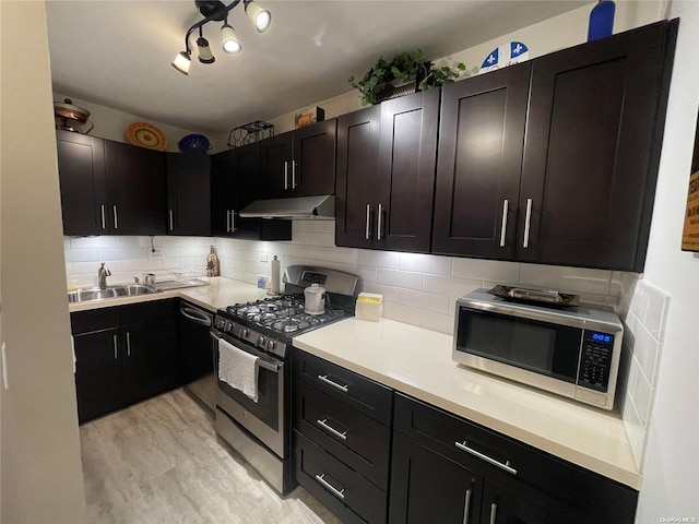 kitchen featuring backsplash, light hardwood / wood-style floors, sink, and appliances with stainless steel finishes