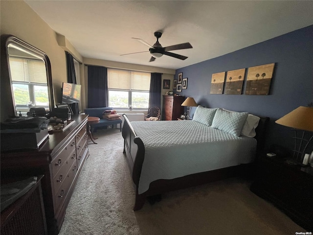 carpeted bedroom featuring multiple windows and ceiling fan