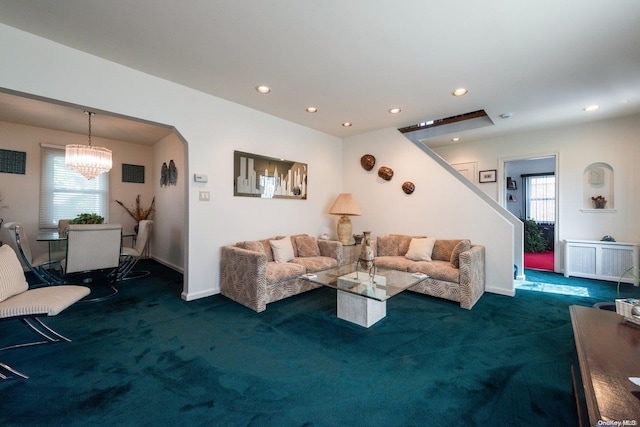 carpeted living room featuring a notable chandelier