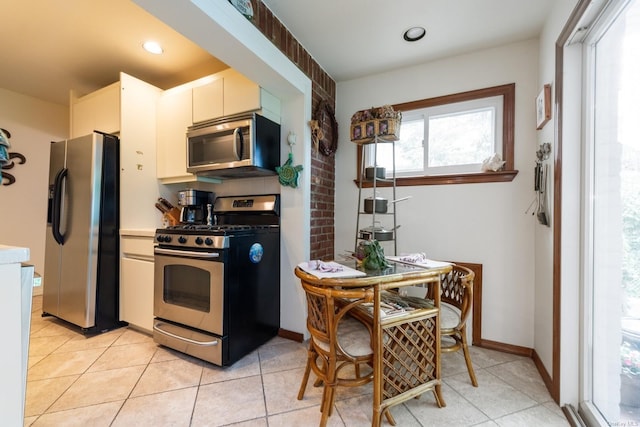 kitchen featuring white cabinets, light tile patterned floors, and stainless steel appliances