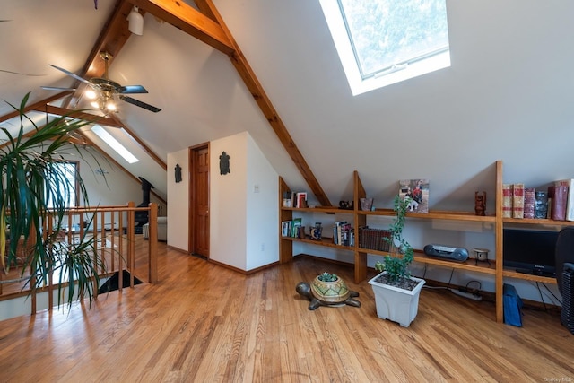 additional living space with high vaulted ceiling, a skylight, light hardwood / wood-style flooring, ceiling fan, and beamed ceiling