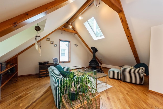 additional living space with light hardwood / wood-style flooring, lofted ceiling with skylight, and a baseboard heating unit