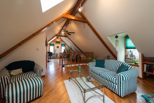 living room with vaulted ceiling with skylight, light wood-type flooring, and a wealth of natural light