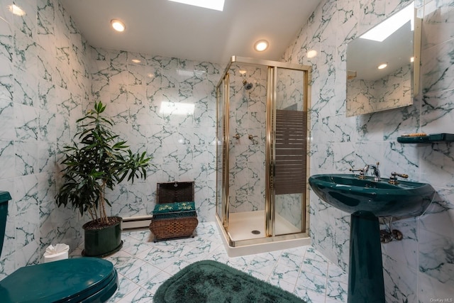 bathroom featuring a shower with door, a baseboard heating unit, sink, tile walls, and toilet