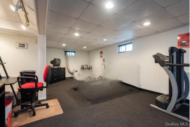 workout area featuring a paneled ceiling and carpet