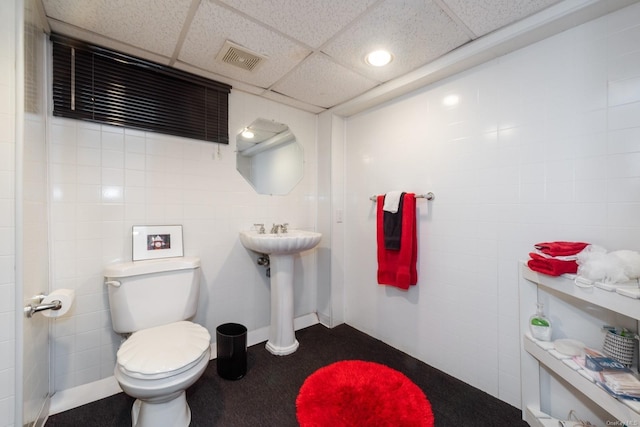 bathroom featuring a paneled ceiling, sink, and toilet