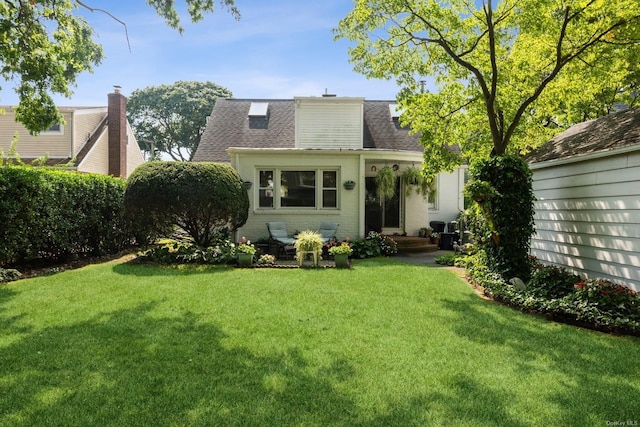 rear view of house featuring a yard