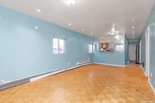 unfurnished living room with light parquet floors and a baseboard heating unit