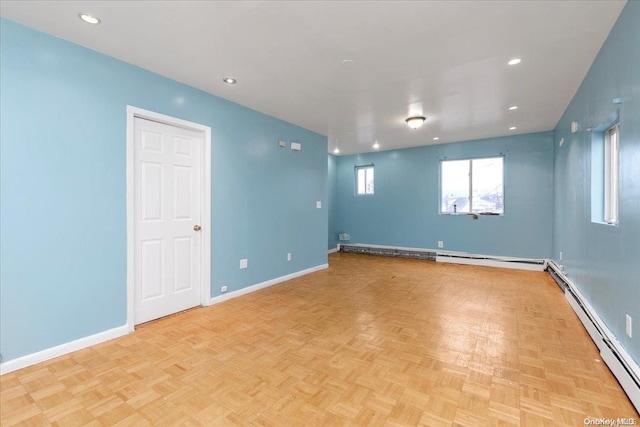 empty room featuring light parquet flooring and a baseboard heating unit