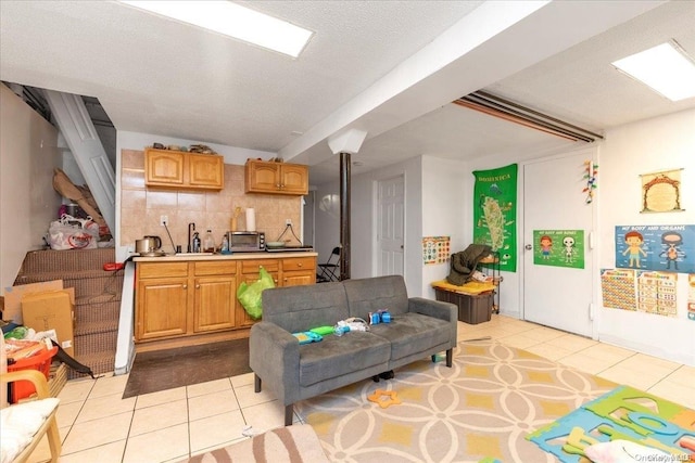 living room with sink, light tile patterned flooring, and a textured ceiling