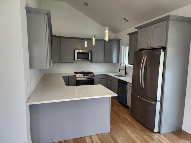 kitchen featuring sink, hanging light fixtures, gray cabinets, kitchen peninsula, and stainless steel appliances