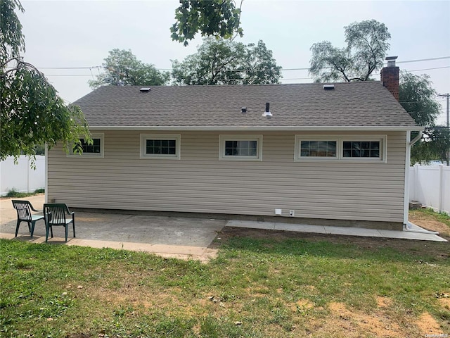 rear view of house with a yard and a patio