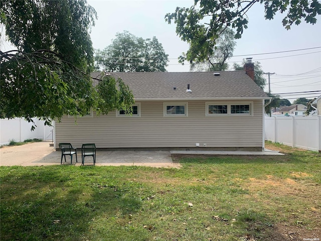 rear view of property with a lawn and a patio