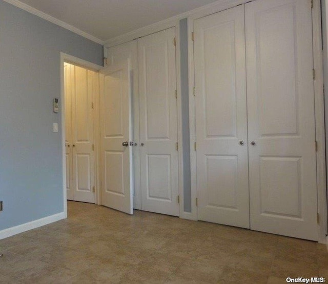 unfurnished bedroom with two closets and crown molding