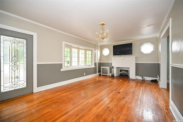 unfurnished living room with radiator, ornamental molding, a chandelier, and hardwood / wood-style flooring