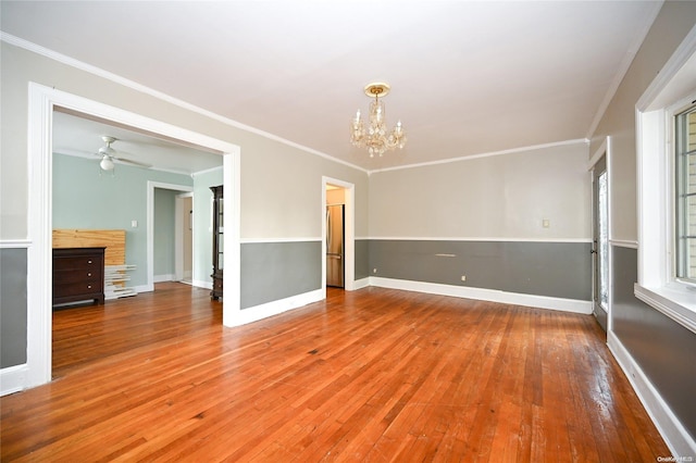 unfurnished room with ceiling fan with notable chandelier, wood-type flooring, and crown molding