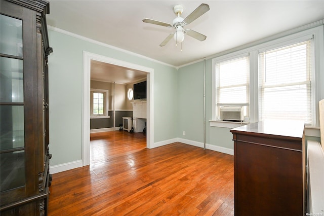 empty room with hardwood / wood-style flooring, ceiling fan, cooling unit, and crown molding