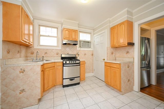 kitchen featuring backsplash, sink, ornamental molding, light tile patterned floors, and stainless steel appliances