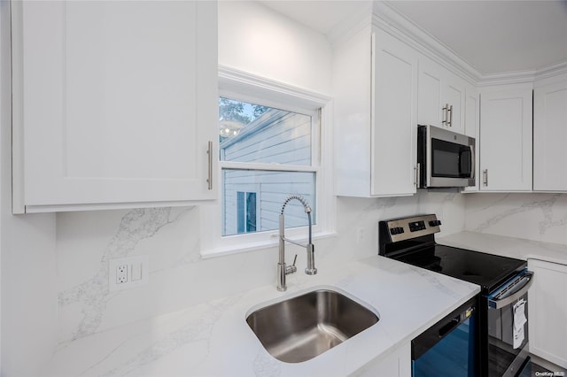 kitchen featuring light stone countertops, white cabinetry, sink, and appliances with stainless steel finishes