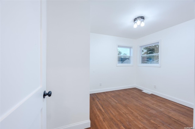 spare room with dark wood-type flooring