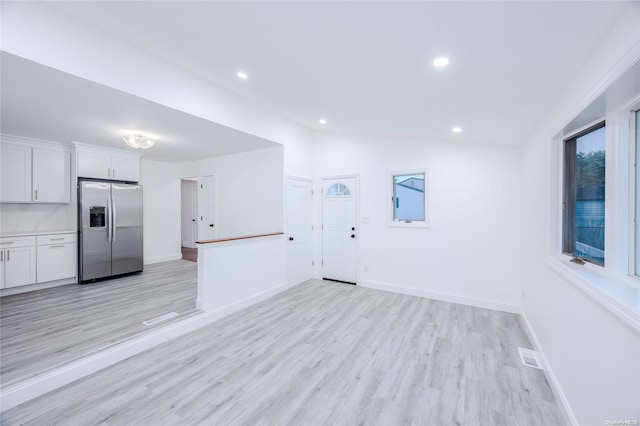 interior space featuring light hardwood / wood-style flooring and lofted ceiling