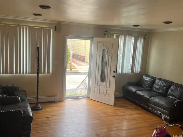 living room with ornamental molding, light hardwood / wood-style flooring, and a baseboard heating unit