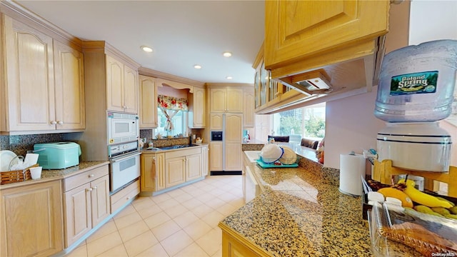 kitchen with decorative backsplash, light brown cabinetry, and white appliances