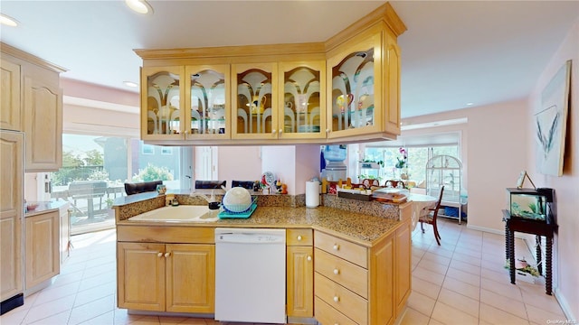 kitchen featuring kitchen peninsula, light brown cabinetry, sink, light tile patterned floors, and dishwasher