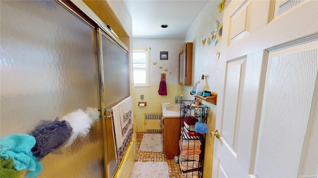 interior space featuring sink, radiator heating unit, and tile walls