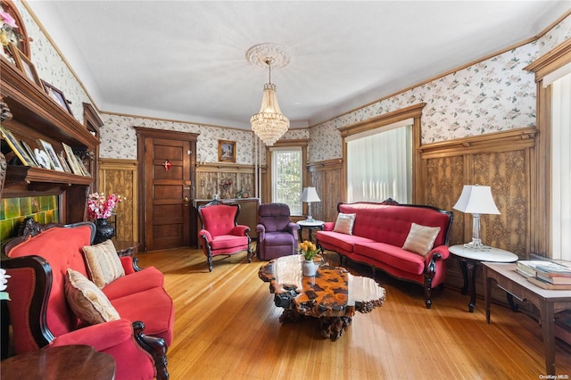 living room with wooden walls, light hardwood / wood-style flooring, and a notable chandelier