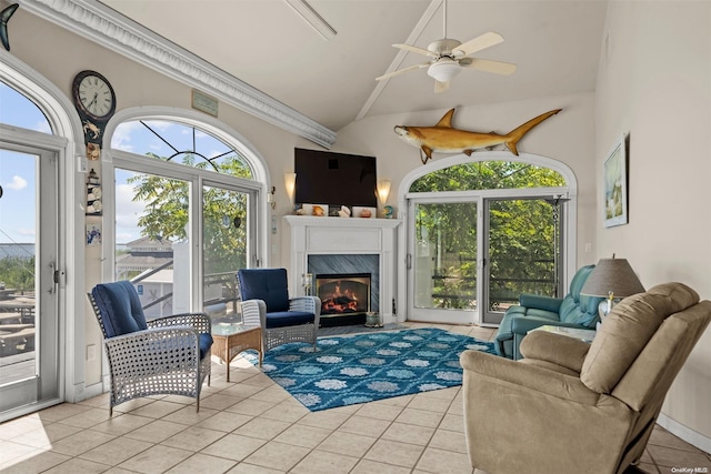 living room with ceiling fan, light tile patterned floors, high vaulted ceiling, and a premium fireplace