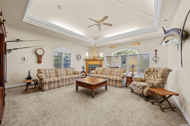 living room featuring a tray ceiling, ceiling fan, and carpet