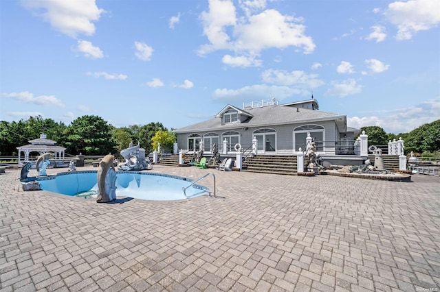 view of swimming pool featuring a gazebo, a patio area, and a water slide