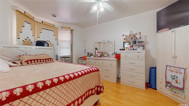 bedroom featuring ceiling fan, cooling unit, and hardwood / wood-style flooring