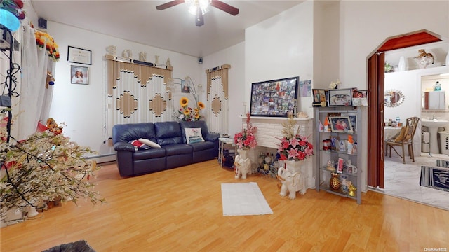 living room featuring ceiling fan, wood-type flooring, and a baseboard heating unit