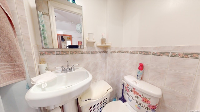 bathroom featuring sink, tile walls, and toilet