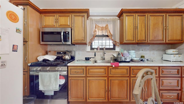 kitchen featuring decorative backsplash, appliances with stainless steel finishes, and sink